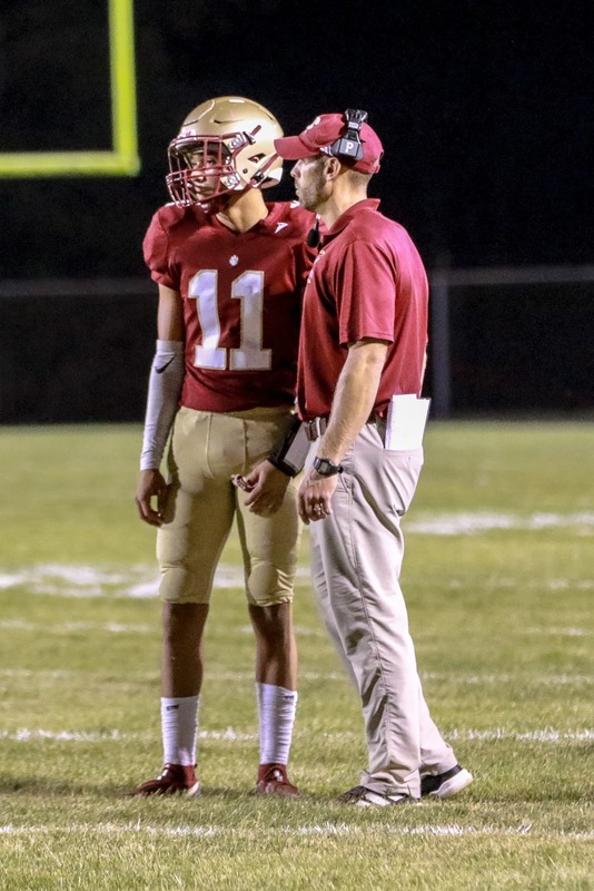 Cougar Head Coach Cam Akers discusses the next play with quarterback Bryant Nottingham